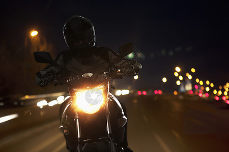 年轻人晚上骑摩托车在北京街上穿过北图片