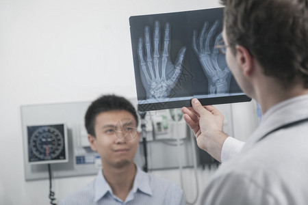医生举起手来看X光检查病人的手骨背图片