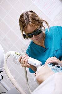 患者正在接受由年轻女临床医生进行的激光焕肤治疗图片