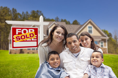 西班牙年轻人幸福的年轻家庭在新家和出售房地产标志前发售图片