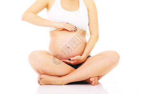 一张孕妇坐在白色背景的一张照片图片