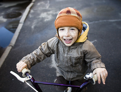 戴着帽子的小可爱男孩骑自行背景图片