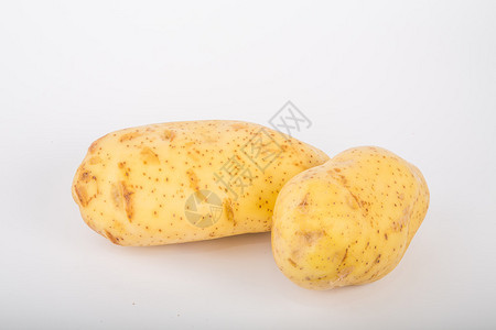 白色柜台上的两个育空金土豆背景图片