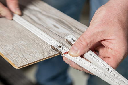 木匠正在测量层板的正确长度图片