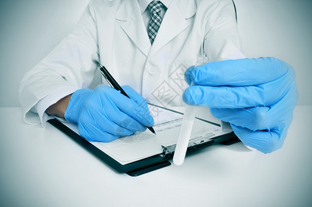 一名男子身着白大衣和蓝色医疗手套手上图片