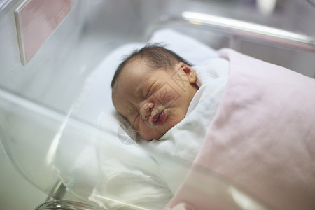 新出生的婴儿在产房的毯子里睡着了图片