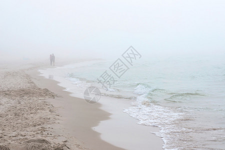 海边有雾的天气波兰莱巴的波罗的海滩沿着海岸线散步的夫妇波兰莱巴的图片