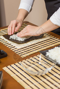 女厨师用手填满日本寿司卷在挪威图片