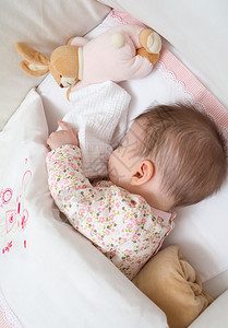 可爱女婴的肖像睡在有奶嘴和填充图片