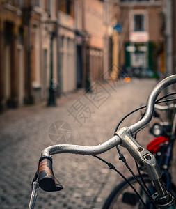雨中自行车在鹅卵石铺成的欧洲后街上的场景图片