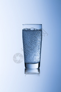 带碳酸气泡的水玻璃sprudelwilli杯饮用解渴饮食健康自来水矿泉水瓶装水蓝色背景在工作室中创建图片