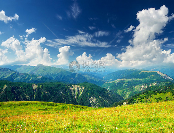 山谷和云雾的天空中的绿色山图片