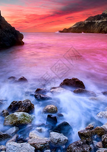 日落时的石头和波浪自然成分图片