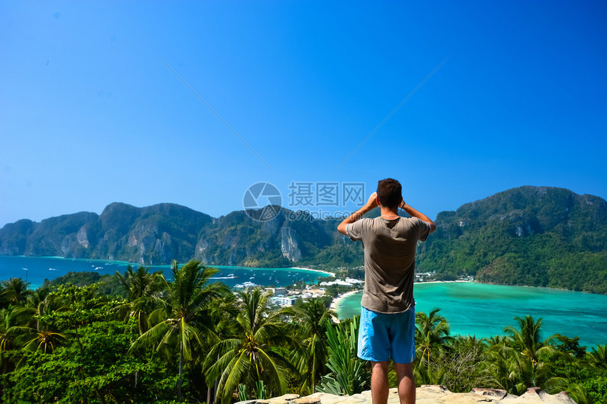 年轻男子在菲济岛顶部拍摄照片图片