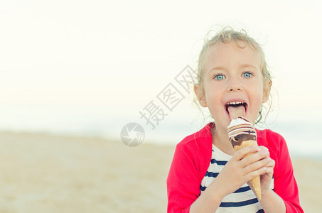 小女孩在沙滩上吃冰淇淋图片