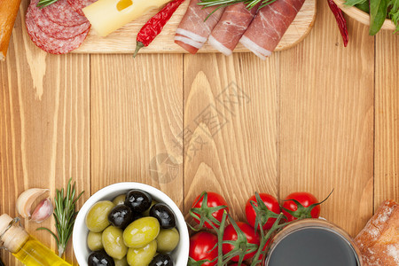 有奶酪橄榄西红柿番茄丙硅酸面包和香料的红葡萄酒在木制图片