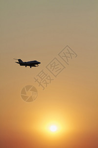 日落时在天空中飞行的公务机图片