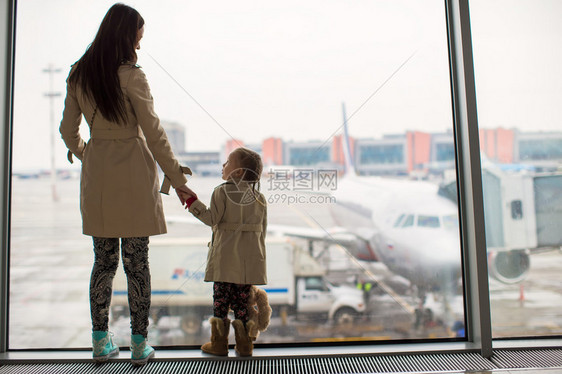 妈和小女儿在机场航站楼望着窗外图片