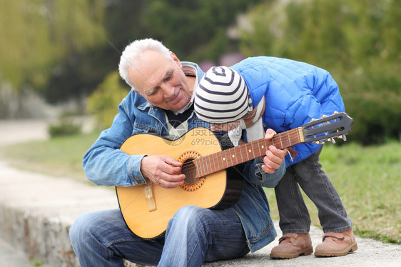 祖父和孙子在户外弹吉他图片