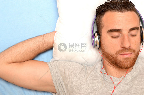 床上戴耳机的男人图片