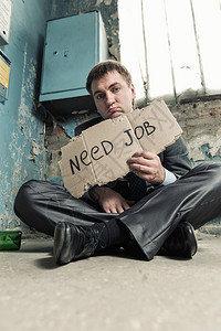 无家可归的商人持有要求新工作的标志图片