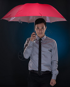 红伞下的亚裔男子图片