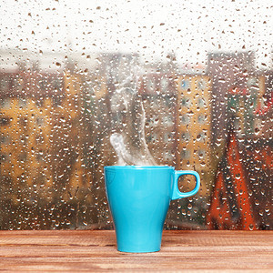 雨天窗口背景的蒸汽咖啡杯Steamingc图片