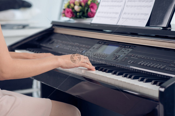 妇女近身在弹钢琴弹中身体和扣子图片