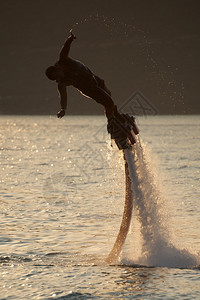 Flyboarder尾随水滴倾入潜水图片
