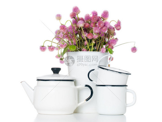 家庭厨房装饰白色花瓶中有趣的粉色野花束老式搪瓷水壶和白色背景图片