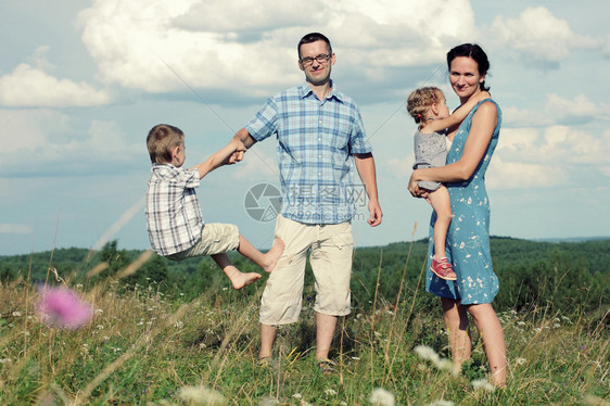 四口欢乐的年轻家庭四口快乐在山顶上玩图片