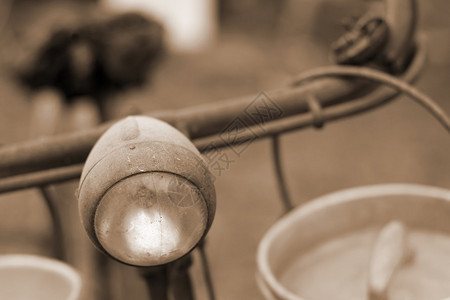 一个奶工的鲁斯提自行车上个世纪的前灯和送新鲜牛奶的图片