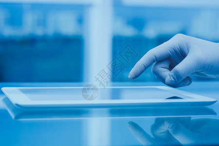 使用数字平板电脑将科学家或医务工作者手图片