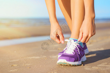 在沙滩上穿跑鞋的女人图片