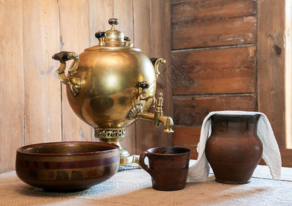 乡间别墅餐桌上的旧茶炊和陶瓷餐具图片