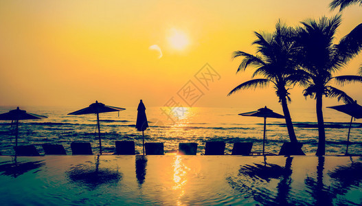 太阳光池海滩和棕榈树日落时间处理古老的星盘背景图片