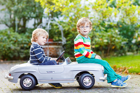 两个快乐的孩子在夏日花园和户外玩大老玩具车双胞胎男孩和朋友图片