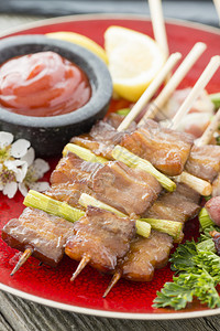 日本寿司拼盘KushiakiButabara白猪肉和Asuparabekon培根包成的腊肠背景