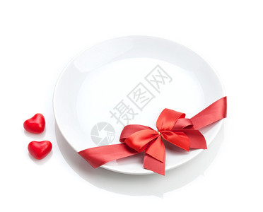 情人节情人节的心脏塑造了糖果和红弓盘子图片
