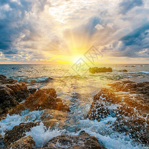 沙滩上日落海浪海浪岩石图片