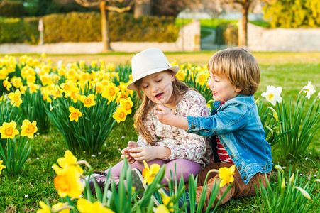 可爱的孩子们在阳光明媚的春日里玩花图片