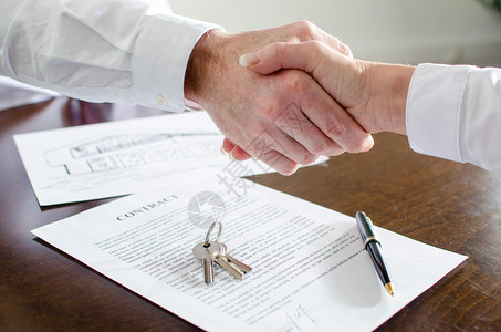 企业代理商在签署合同后与其客户握手背景图片