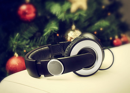 耳机停在圣诞树附近的白色皮革沙发上是圣图片