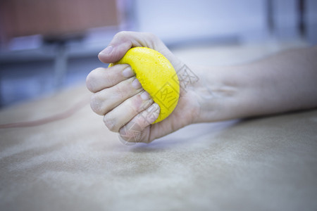 身体受伤和风湿关节炎的女病人在医院诊所用手挤压理疗球图片