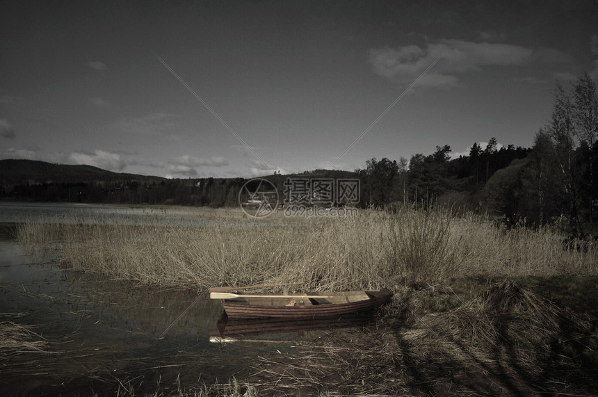 浅薄的浮游艇在湖面上的照片一个清晨平图片