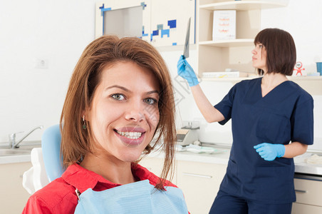 妇女病人微笑和女牙医生检查背景的放射线图片