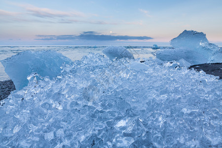 冰岛日落时在Jokulsarlon冰川环礁湖海滩附近漂图片