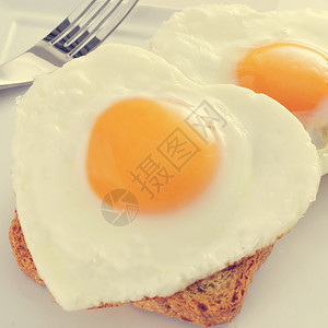 关闭一些心形炸鸡蛋在烤面包上使用并图片