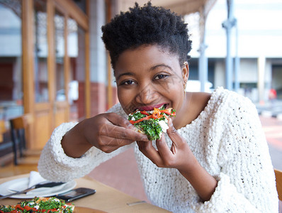一位快乐的非裔美国女人吃披萨图片