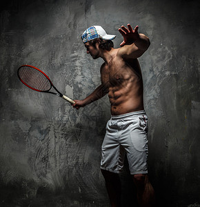 有球拍的男网球运动员在行动图片